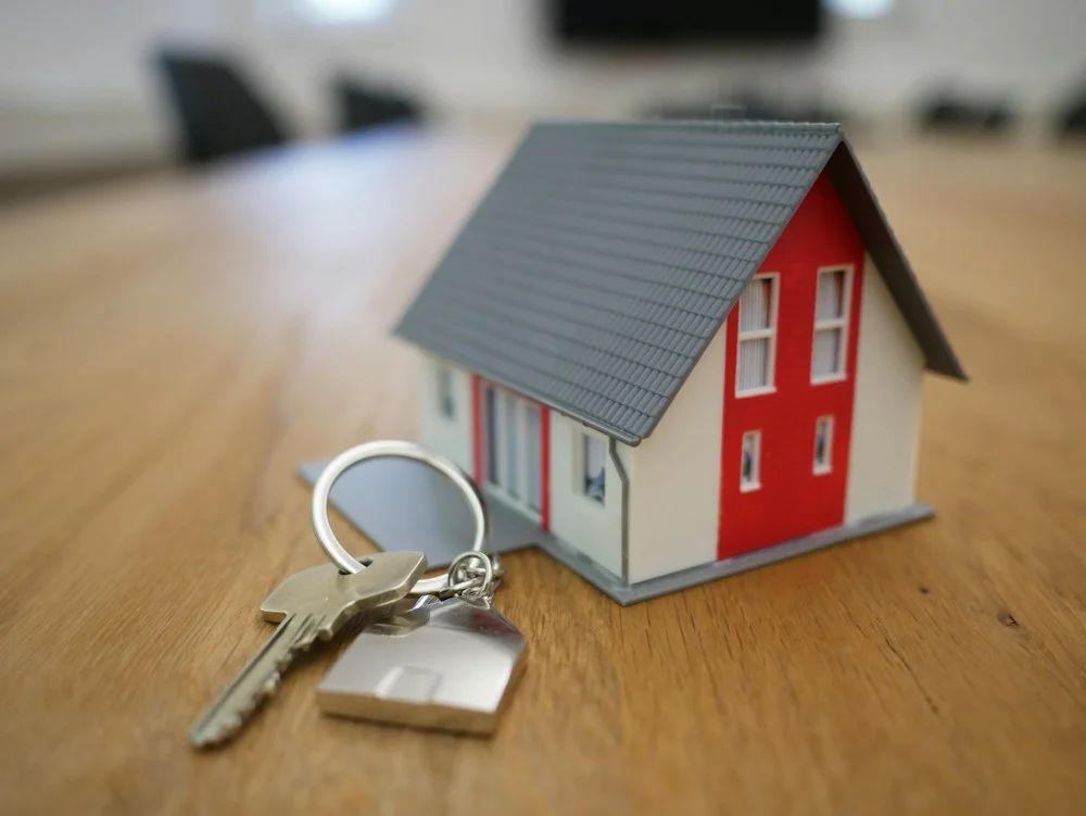 House keys beside a model home on a table
